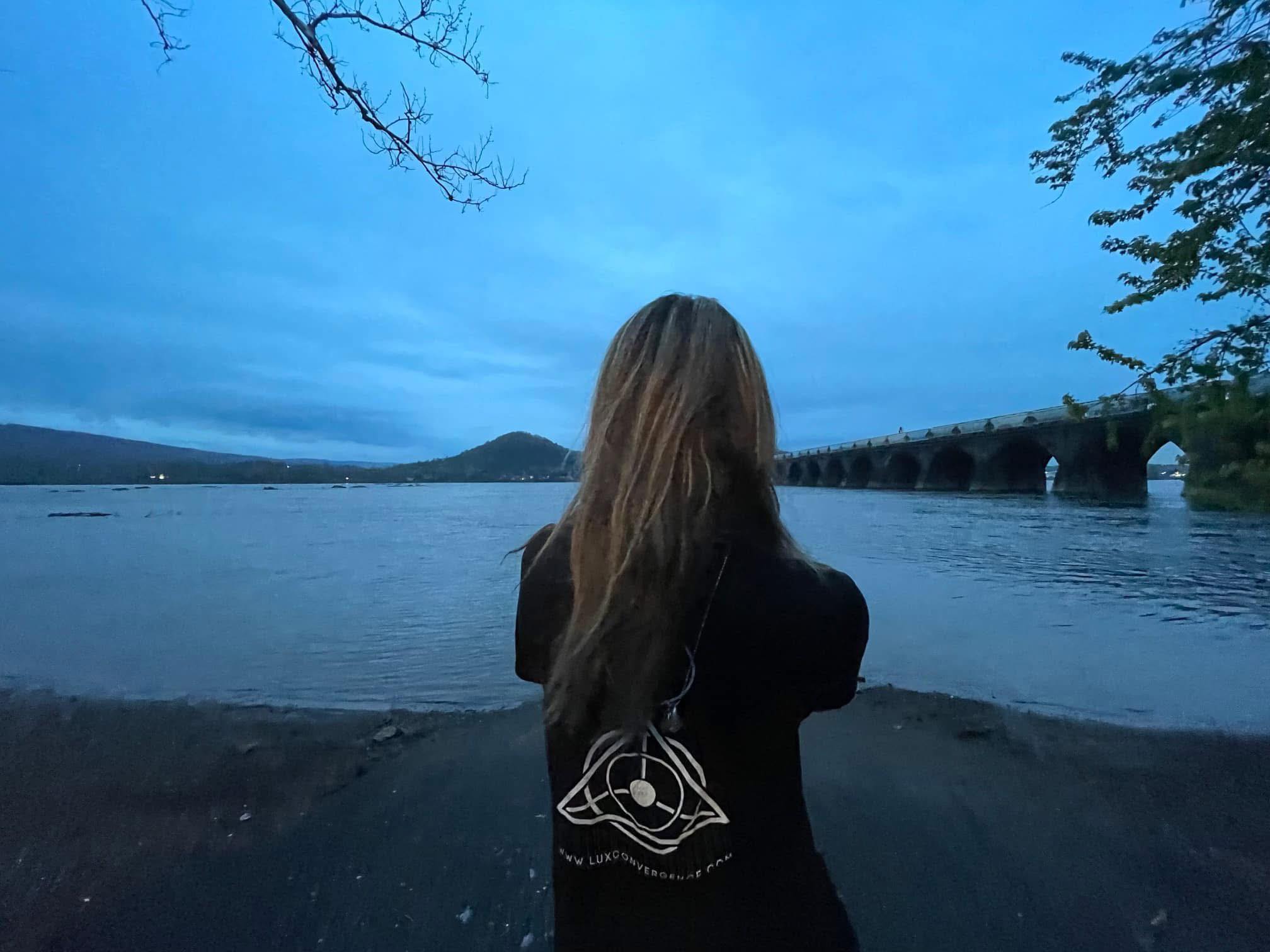Woman standing by the Susquehanna River at dusk